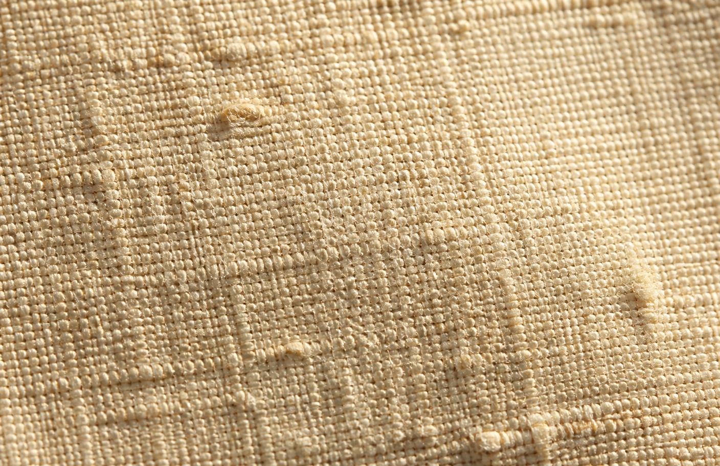Detalle macro de la trama de una tela de tussor de algodón crudo
